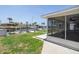 Home featuring a screened-in porch, canal views, boat dock, and green grass at 15713 Century Dr, Hudson, FL 34667