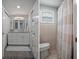 Well-lit bathroom with dual mirrors over a vanity with a tiled shower and window at 15713 Century Dr, Hudson, FL 34667
