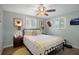 Sunlit bedroom with coastal decor, ceiling fan, and comfy black metal frame bed at 15713 Century Dr, Hudson, FL 34667
