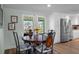 Charming dining area with water views, a round table, and white cabinets with stainless steel refrigerator at 15713 Century Dr, Hudson, FL 34667