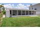 A screened-in porch on a green lawn with a white exterior at 15713 Century Dr, Hudson, FL 34667