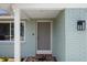 Charming front entrance with light blue brick, white trim, and a welcoming welcome mat at 15713 Century Dr, Hudson, FL 34667