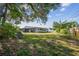 Backyard with lush lawn, mature trees and full landscaping, plus view of screened porch at 1701 62Nd S Ter, St Petersburg, FL 33712