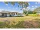Backyard with lush lawn, mature trees and full landscaping, plus view of screened porch at 1701 62Nd S Ter, St Petersburg, FL 33712