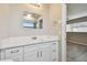Bright bathroom with vanity featuring white cabinets, marble-look counter, and a view to bedroom at 1701 62Nd S Ter, St Petersburg, FL 33712