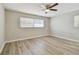 Bright bedroom features wood-look flooring, ceiling fan, and natural light from large windows at 1701 62Nd S Ter, St Petersburg, FL 33712