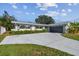 Charming single-story home featuring a grey garage door, well-manicured lawn and a long driveway leading to the entrance at 1701 62Nd S Ter, St Petersburg, FL 33712