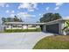 Charming single-story home featuring a grey garage door, well-manicured lawn and a long driveway leading to the entrance at 1701 62Nd S Ter, St Petersburg, FL 33712