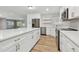Renovated kitchen with stainless steel appliances, white cabinets, and a large island overlooking the living area at 1701 62Nd S Ter, St Petersburg, FL 33712