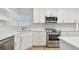 A modern kitchen features stainless steel appliances, stylish cabinets, and elegant fixtures at 1701 62Nd S Ter, St Petersburg, FL 33712