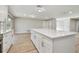 A kitchen island with stone countertops and white cabinets provides ample space in an open-concept living area at 1701 62Nd S Ter, St Petersburg, FL 33712