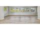 Bright living room featuring light wood flooring, neutral walls, and lots of windows for natural light and outdoor views at 1701 62Nd S Ter, St Petersburg, FL 33712