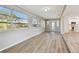Well-lit living room featuring plank floors, neutral walls, an exterior door, and a view of the kitchen at 1701 62Nd S Ter, St Petersburg, FL 33712