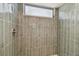 Shower area with unique glossy green tiles, shower head, and a frosted window at 1701 62Nd S Ter, St Petersburg, FL 33712