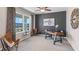 A modern home office features stylish decor, a large window, a ceiling fan, and neutral carpeting at 1703 Tahitian Sunrise Dr, Plant City, FL 33565