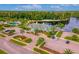 Aerial view showing the clubhouse, a pool, sandy beach, and lakeside recreation areas at 18050 Cozumel Isle Dr, Tampa, FL 33647