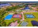 Aerial view of community with multi-sport courts, pool, clubhouse, and beautiful winding lake at 18050 Cozumel Isle Dr, Tampa, FL 33647