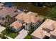 An aerial view of a two-story home boasting a tile roof, paved driveway and access to the water at 18050 Cozumel Isle Dr, Tampa, FL 33647