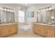 Luxurious bathroom with a soaking tub between matching vanities and large mirrors at 18050 Cozumel Isle Dr, Tampa, FL 33647
