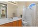 Bright bathroom featuring a round window, shower-tub combination, and wood vanity at 18050 Cozumel Isle Dr, Tampa, FL 33647