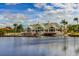 Exterior view of clubhouse on a lake with pier and beautiful blue sky reflecting in the water at 18050 Cozumel Isle Dr, Tampa, FL 33647
