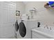 Laundry room with front loading washer/dryer, sink, and wire shelving at 18050 Cozumel Isle Dr, Tampa, FL 33647