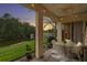 Covered patio overlooking the river with dining table set, lights, and peaceful landscaping at 18050 Cozumel Isle Dr, Tampa, FL 33647