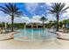 Resort-style community pool with fountains, palm trees, lounge chairs, and a covered pavilion area at 18050 Cozumel Isle Dr, Tampa, FL 33647