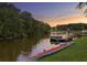 Waterfront view of a kayak and boat along a serene river with lush trees against sunset sky at 18050 Cozumel Isle Dr, Tampa, FL 33647