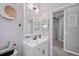 This bathroom has a modern vanity, large mirror, and stylish fixtures, and leads to the hallway with wood-look flooring at 19309 Garden Quilt Cir, Lutz, FL 33558