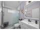 Updated bathroom featuring subway tile in shower, glass door, modern vanity with black hardware, and decorative mirror at 19309 Garden Quilt Cir, Lutz, FL 33558