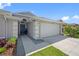 Home's entrance with a well-kept lawn, leading to a two-car garage at 19309 Garden Quilt Cir, Lutz, FL 33558