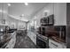 Bright kitchen with white cabinets, black granite countertops, stainless steel appliances and eat-in dining area nearby at 19309 Garden Quilt Cir, Lutz, FL 33558