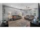 Cozy living room with gray couches, stylish rug, ceiling fan, recessed lighting, and easy access to the outdoor pool at 19309 Garden Quilt Cir, Lutz, FL 33558