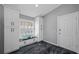 Bright mud room featuring a window seat, custom cabinetry, and luxury vinyl tile flooring at 19309 Garden Quilt Cir, Lutz, FL 33558