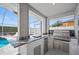 Well-equipped outdoor kitchen features stainless steel grill, marble countertop, and convenient mini-fridge next to screened-in pool at 19309 Garden Quilt Cir, Lutz, FL 33558