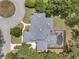 Aerial view featuring a pool and screened in patio surrounded by mature trees and manicured lawn at 2011 Water Wheel Ct, Dunedin, FL 34698