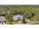 Aerial view showcasing the house on a tree-lined street with backyard and pool in the background at 2011 Water Wheel Ct, Dunedin, FL 34698