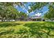 Lush backyard with mature trees and a screened-in pool area, offering a serene outdoor space at 2011 Water Wheel Ct, Dunedin, FL 34698