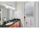Bathroom featuring dark granite countertops, wood cabinets, and a door to the pool area at 2011 Water Wheel Ct, Dunedin, FL 34698