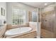Bright bathroom showcasing a soaking tub with a glass block window and a walk-in shower at 2011 Water Wheel Ct, Dunedin, FL 34698