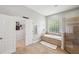 Bright bathroom featuring a soaking tub, glass block window, and tiled walk-in shower at 2011 Water Wheel Ct, Dunedin, FL 34698