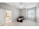 Bright bedroom featuring neutral walls, a ceiling fan, and an adjacent bathroom, offering a tranquil retreat at 2011 Water Wheel Ct, Dunedin, FL 34698
