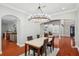 Elegant dining room featuring a modern chandelier, hardwood floors, and a view to the kitchen at 2011 Water Wheel Ct, Dunedin, FL 34698