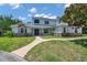Charming home with stone accents, lush lawn, and welcoming walkway leading to the front door at 2011 Water Wheel Ct, Dunedin, FL 34698