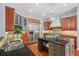 Spacious kitchen with granite countertops, center island, custom cabinets, and stainless steel appliances at 2011 Water Wheel Ct, Dunedin, FL 34698
