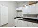 Laundry room features white cabinets, granite countertops, and a utility sink at 2011 Water Wheel Ct, Dunedin, FL 34698
