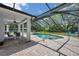 Enclosed pool area with poolside seating and covered patio, creating a perfect space for outdoor relaxation and entertainment at 2011 Water Wheel Ct, Dunedin, FL 34698
