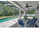 Screened pool area featuring a modern ceiling fan, poolside furniture, and ample natural light, perfect for entertaining at 2011 Water Wheel Ct, Dunedin, FL 34698