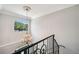 Staircase with wrought iron railing, chandelier, crown molding, and an arched window at 2011 Water Wheel Ct, Dunedin, FL 34698